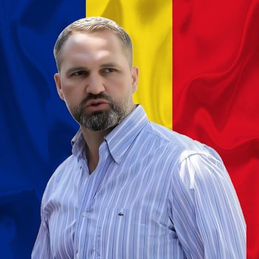 Mihai Lasca, cu steagul României pe fundal