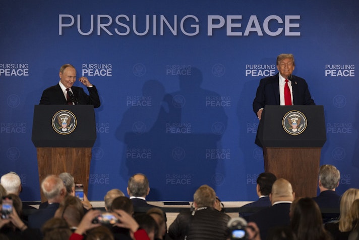 Doi lideri politici vorbesc de la pupitre separate, în fața unei audiențe, pe un fundal albastru cu mesajul «Pursuing Peace».