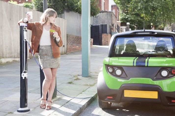 Femeie langa o masina electrica