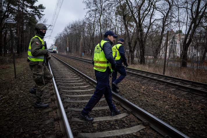 Polonezi patrulând șine de tren după o recentă explozie cauzată de suspecți de spionaj pentru Rusia