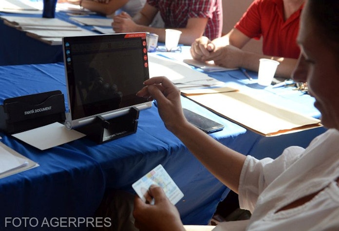 Un operator de calculator al sectiei de votare introduce datele personale ale unui alegator