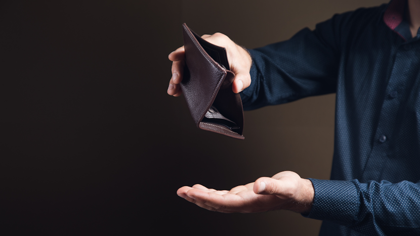bărbat care tine un portofel gol