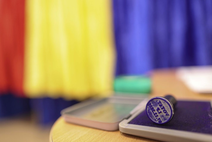 ștampilă de vot pe o masă într-o secție de votare