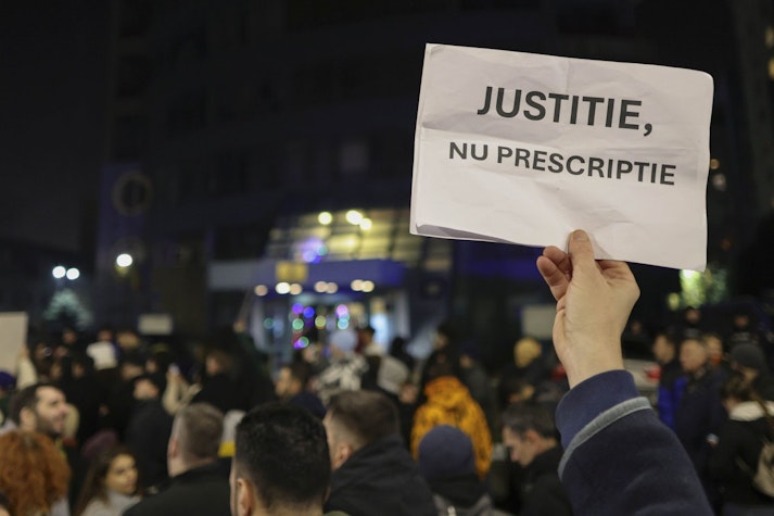 un protestatar ține ridicată o coală de hârte cu mesajul „justiție, nu prescripție”