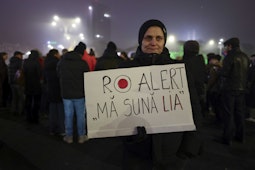 Protestatară care tine in maini o pancarta