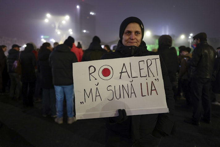 Protestatară care tine in maini o pancarta