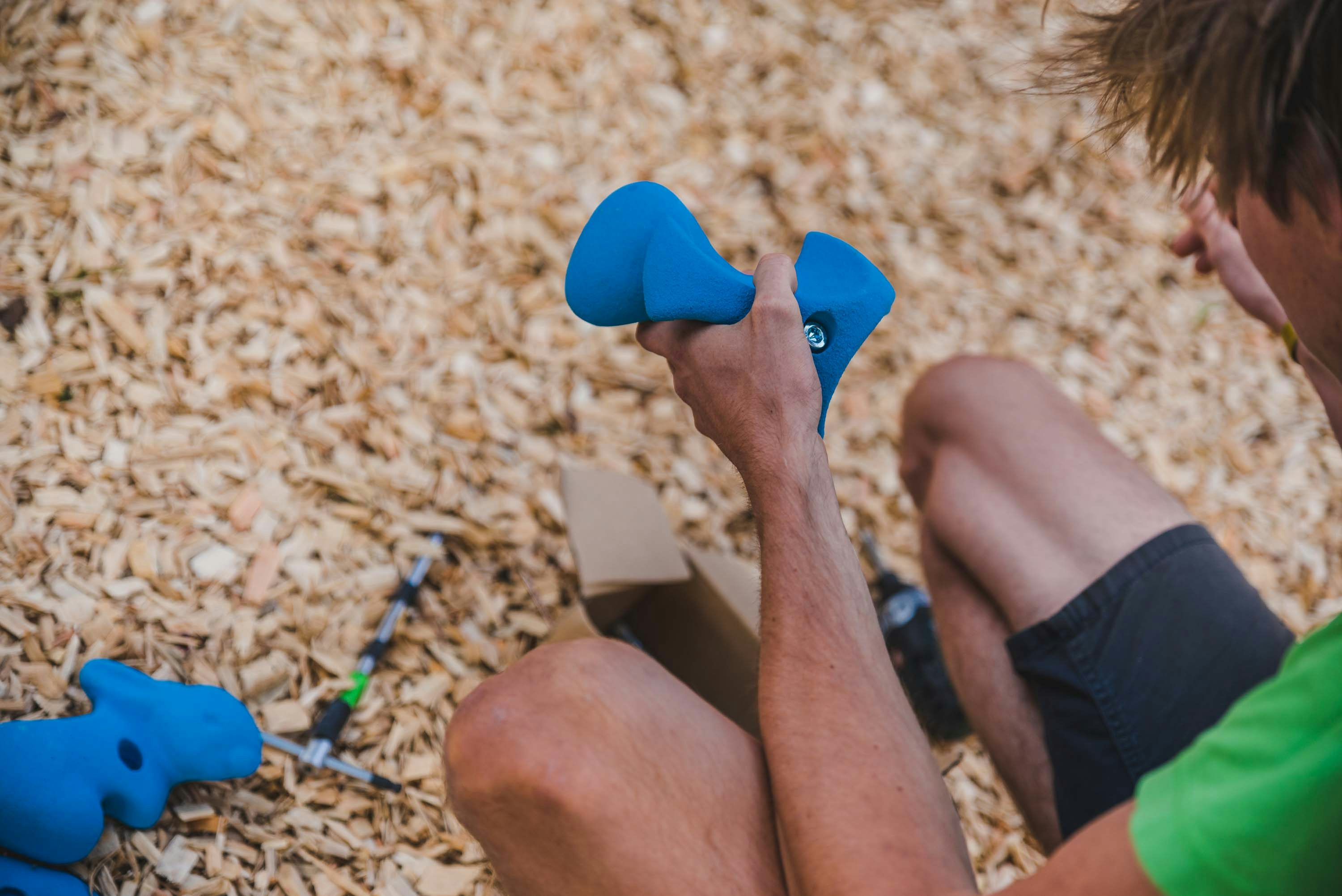 Ein Trainer wählt Griffe für den Boulderwürfel aus