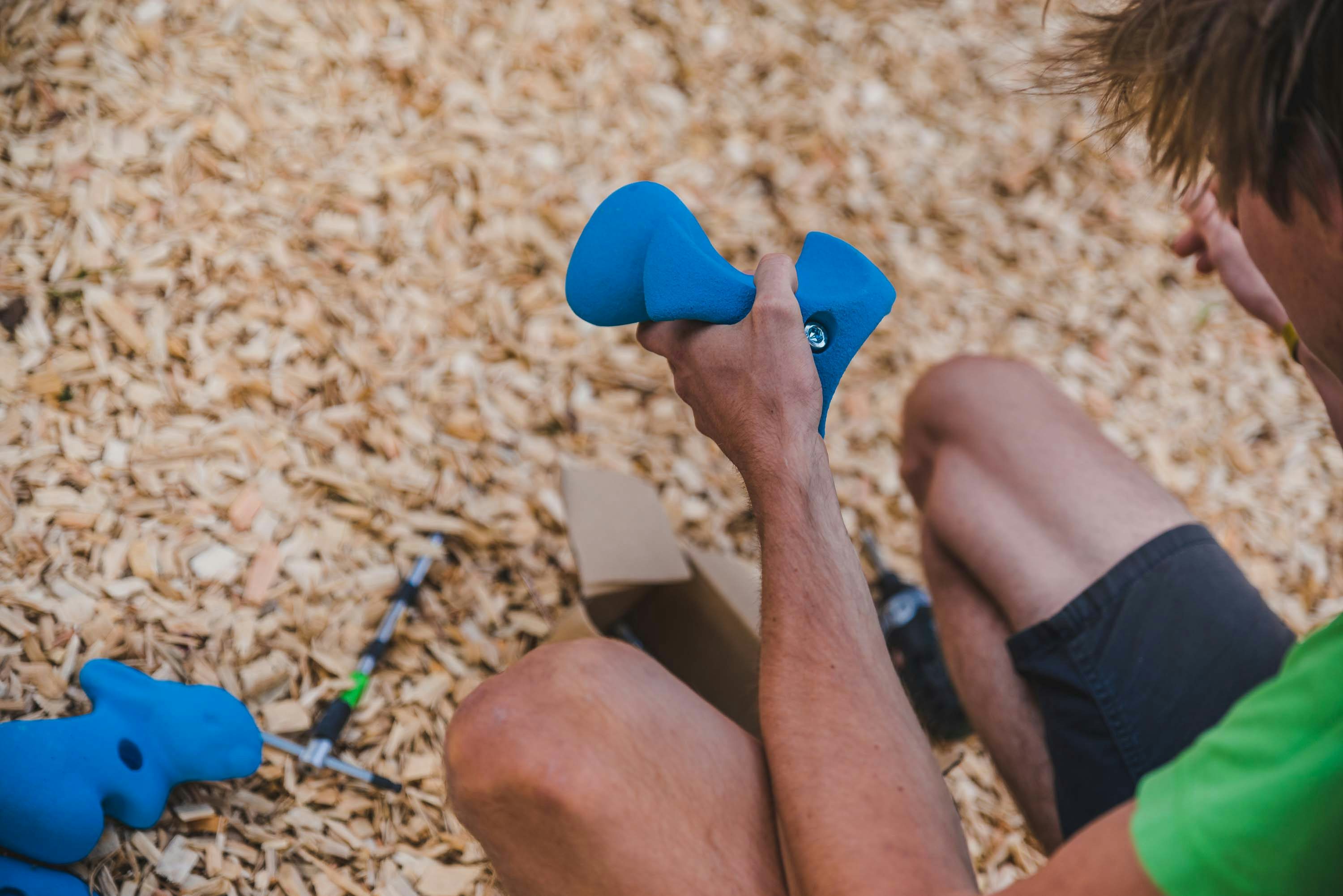 Ein Trainer wählt Griffe für den Boulderwürfel aus 