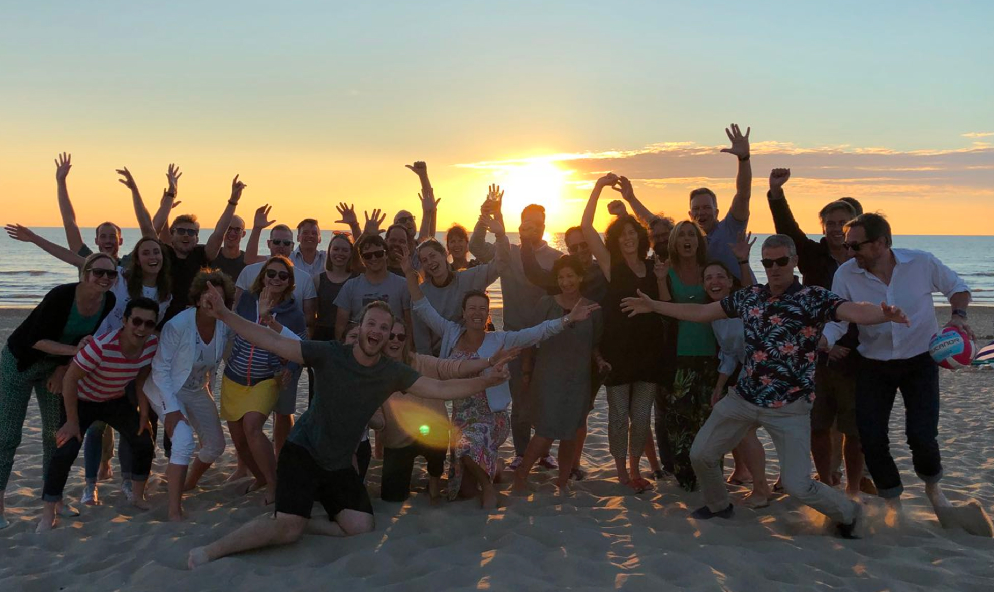 De zwaaiende medewerkers van Informaat op het strand