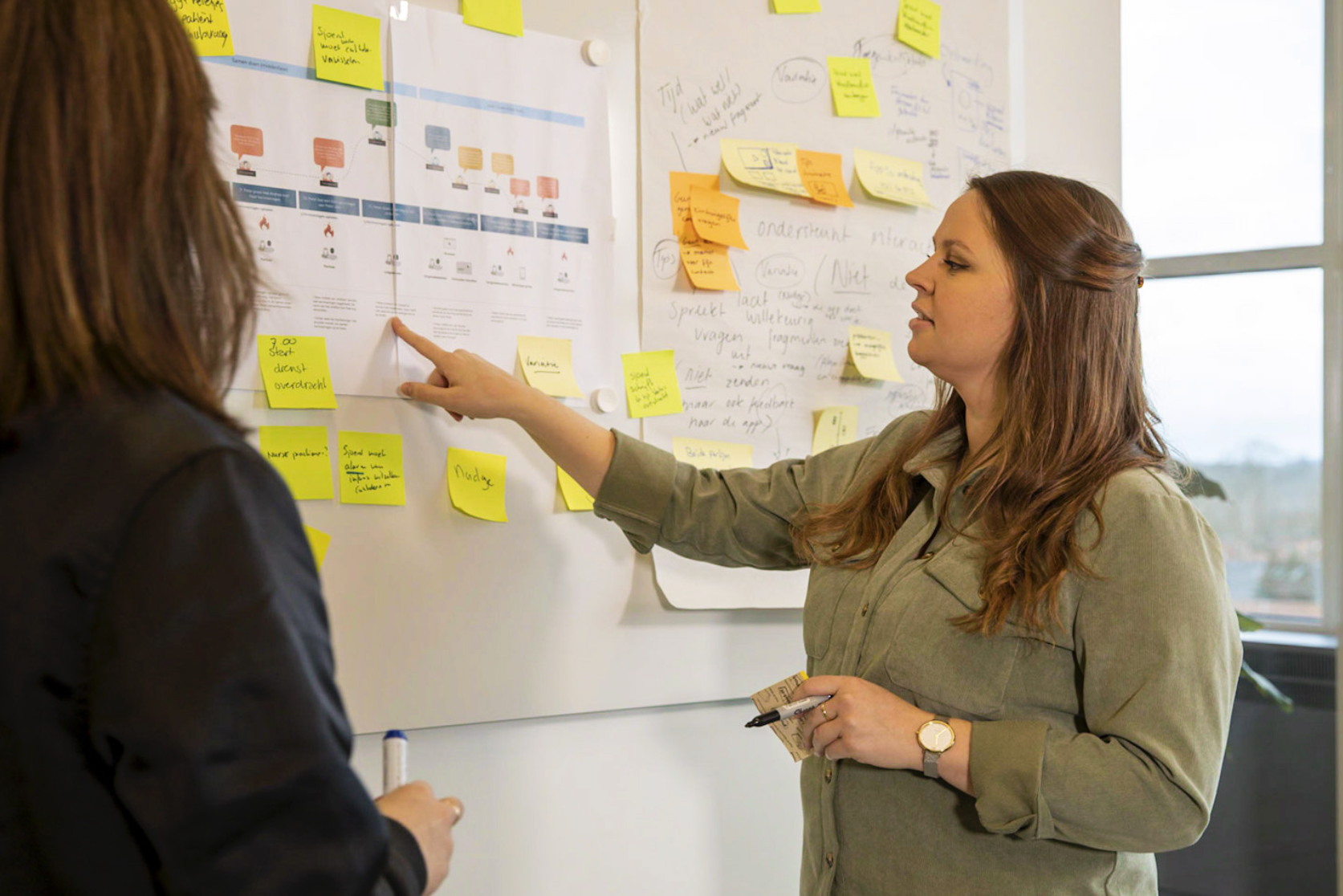 designer in front of wall with sticky notes