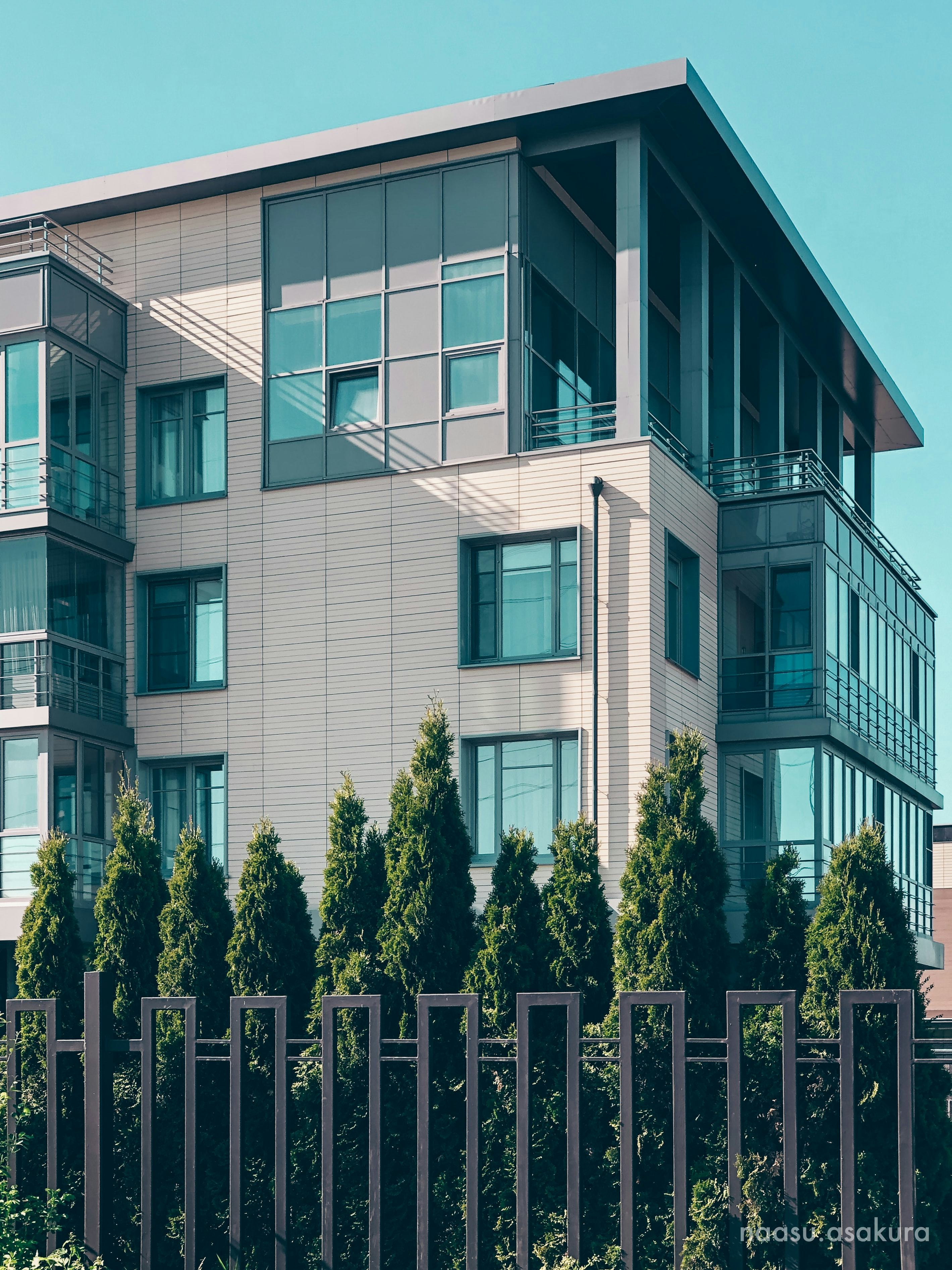 Condo with trees lined in front.