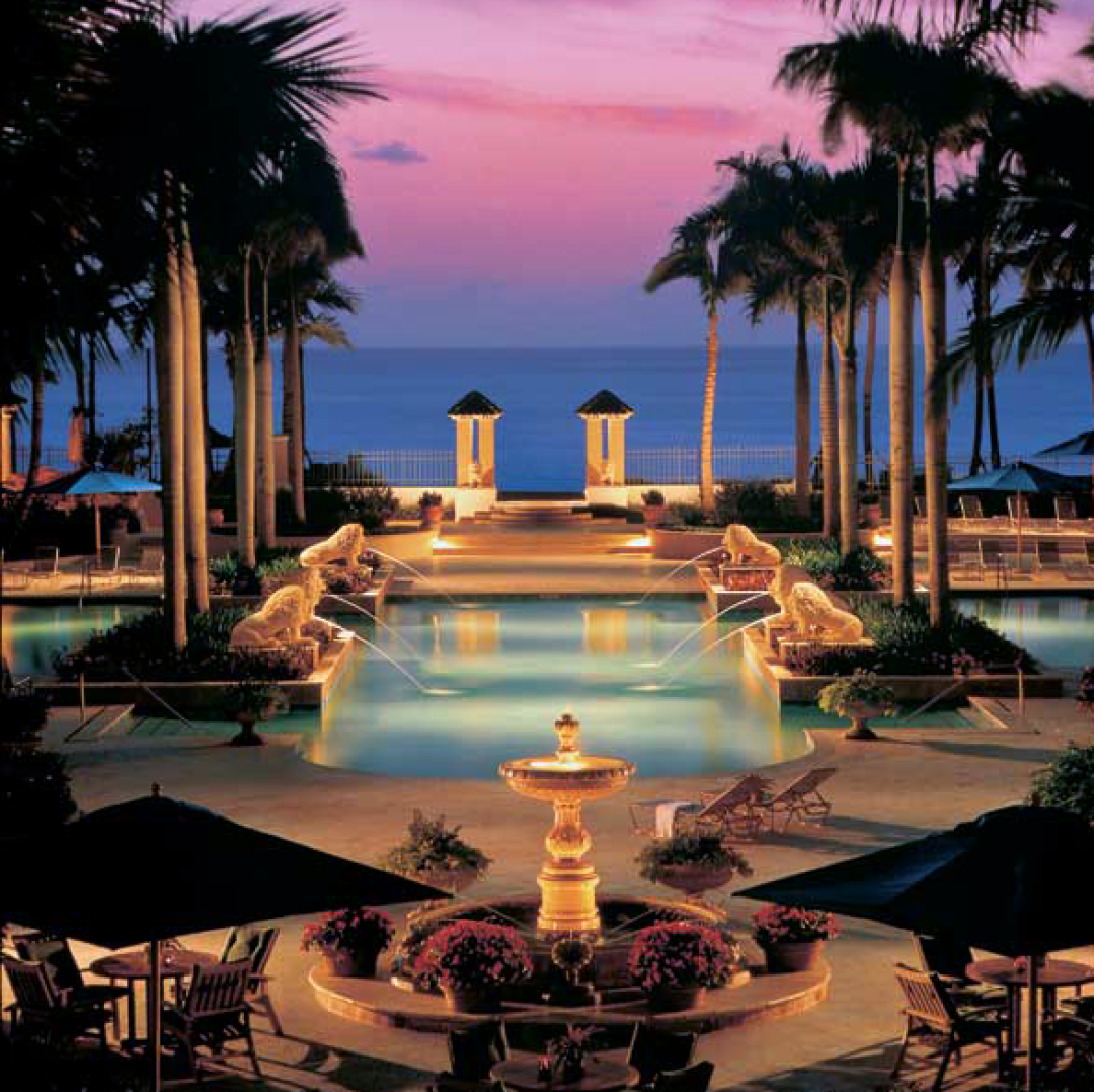 Oceanfront pool with gradient sky and palm trees