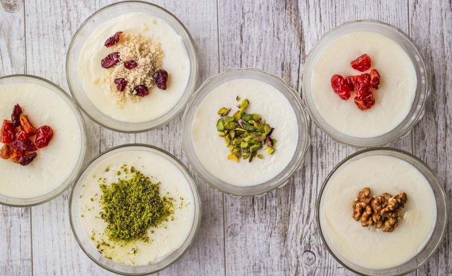 farklı meyveler ve kuruyemişlerle süslenmiş muhallebi sunumları