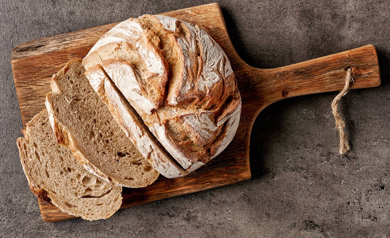 ekmek kesme tahtasi üzerinde dilimlenmiş tam buğday ekmegi