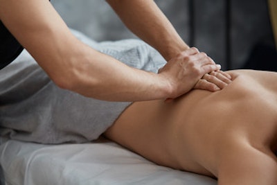 Male therapist delivering a deep tissue massage