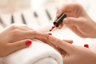 Nail technician applying nail polish