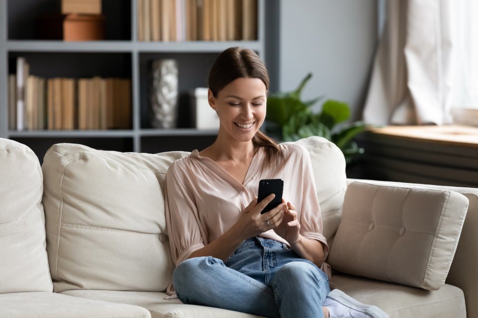 Woman relaxing at home on her phone