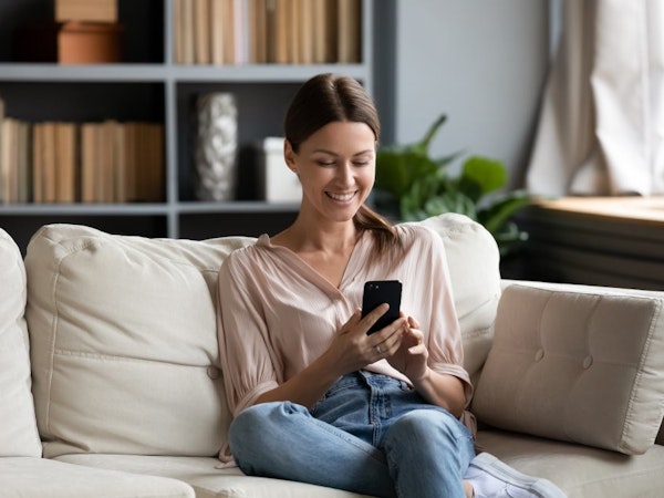 Woman relaxing at home on her phone