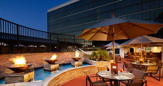 Hilton Anaheim hotel exterior with fire braziers and patio dining tables