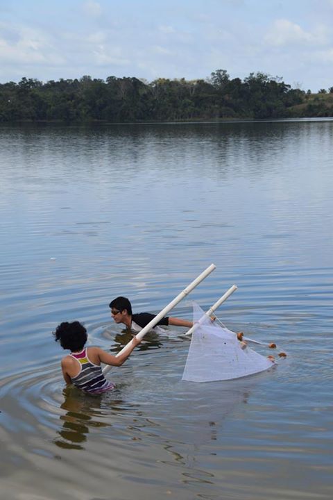 Diego and Universidad de San Carlos student Wendy pull a seine through the shore of a lake to catch fishes.
