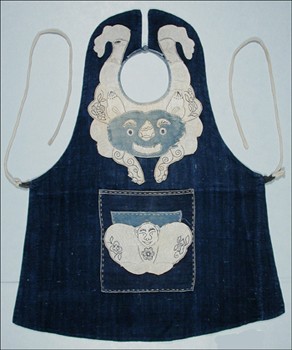 A tiger is smartly appliquéd around the neck of this apron. This kind of guardian spirit image tends to be striking in order to scare off evil spirits. On the front pocket is the design of yi tuan he qi (great harmony and happiness) which the Chinese use as a way of wishing for concordance with others. Yi tuan he qi is represented here as a happy monk, in the shape of a yuanbao (shoe-shaped gold ingot). Yi tuan he qi is also sometimes presented as a boy or a girl.
 
Bag52.4cm x 43.2cmSichuan ProvinceHan ChineseCotton2724.234755© The Field Museum