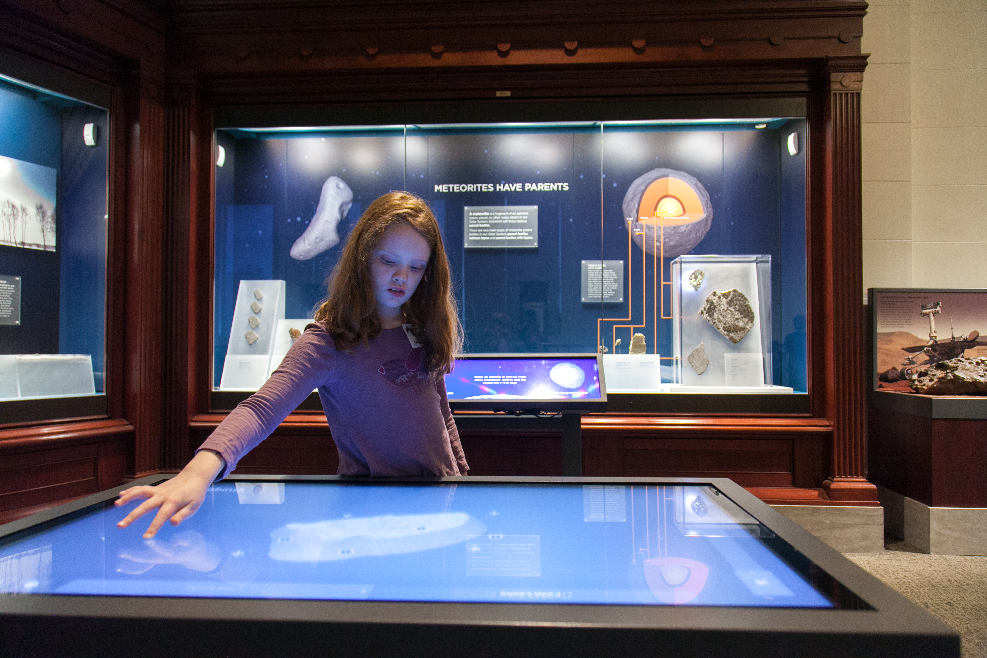 Girl in the meteorites gallery using a touch screen