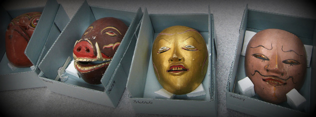 carved and painted masks in storage boxes