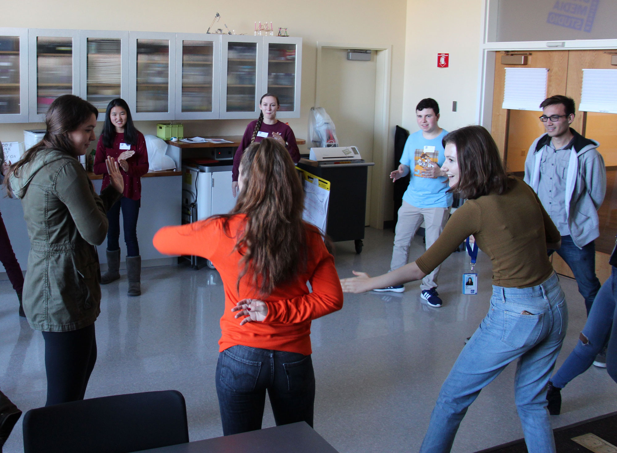 Youth Council members stand in a circle playing an intense game of Ninja. They all hold their hands up waiting for the next player to make the next move.