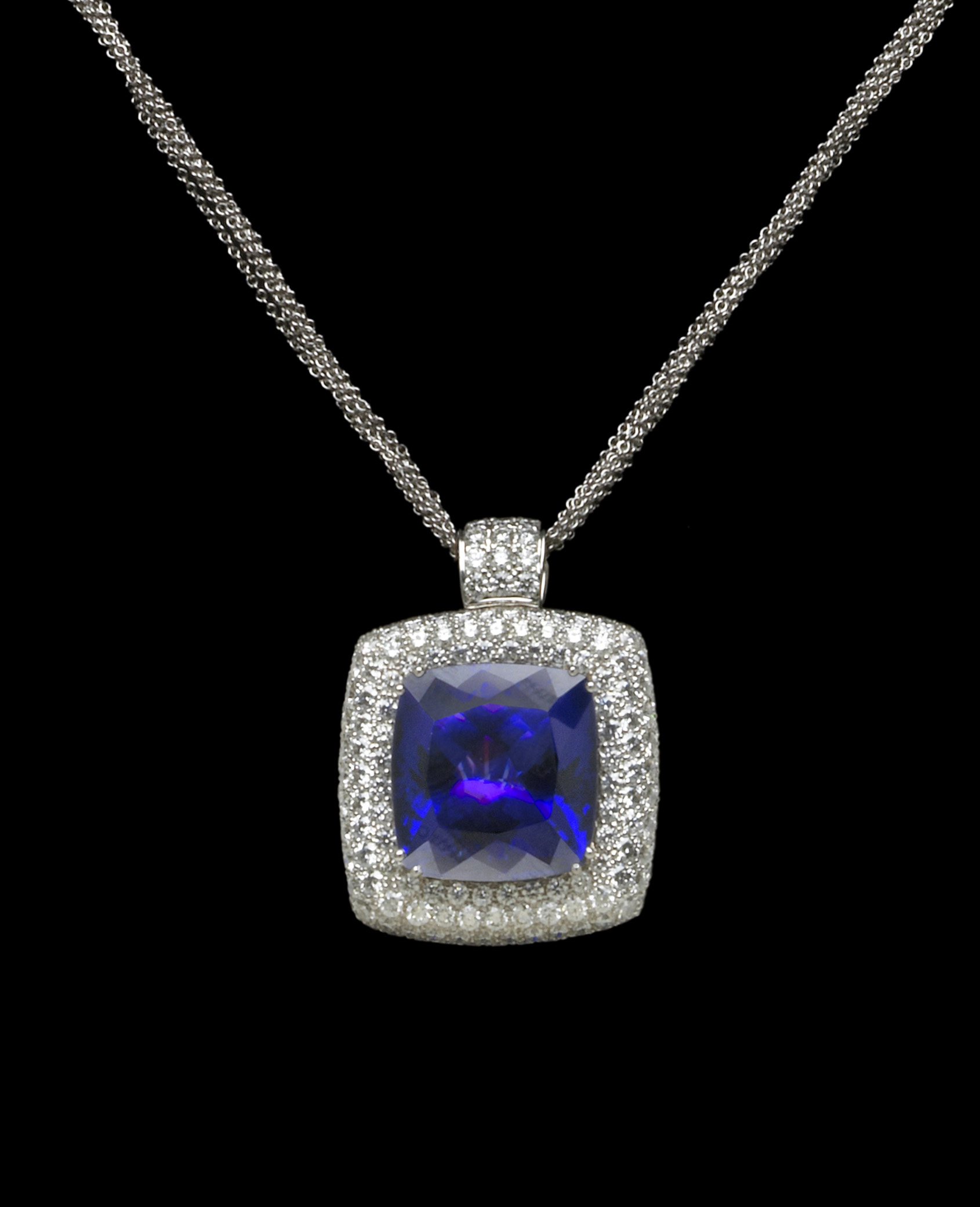 A Tanzanite necklace with a blue 37-carat rounded square brilliant-cut tanzanite surrounded by Diamonds and set in 18-karat white Gold. Pendant measures 27 mm in diameter.