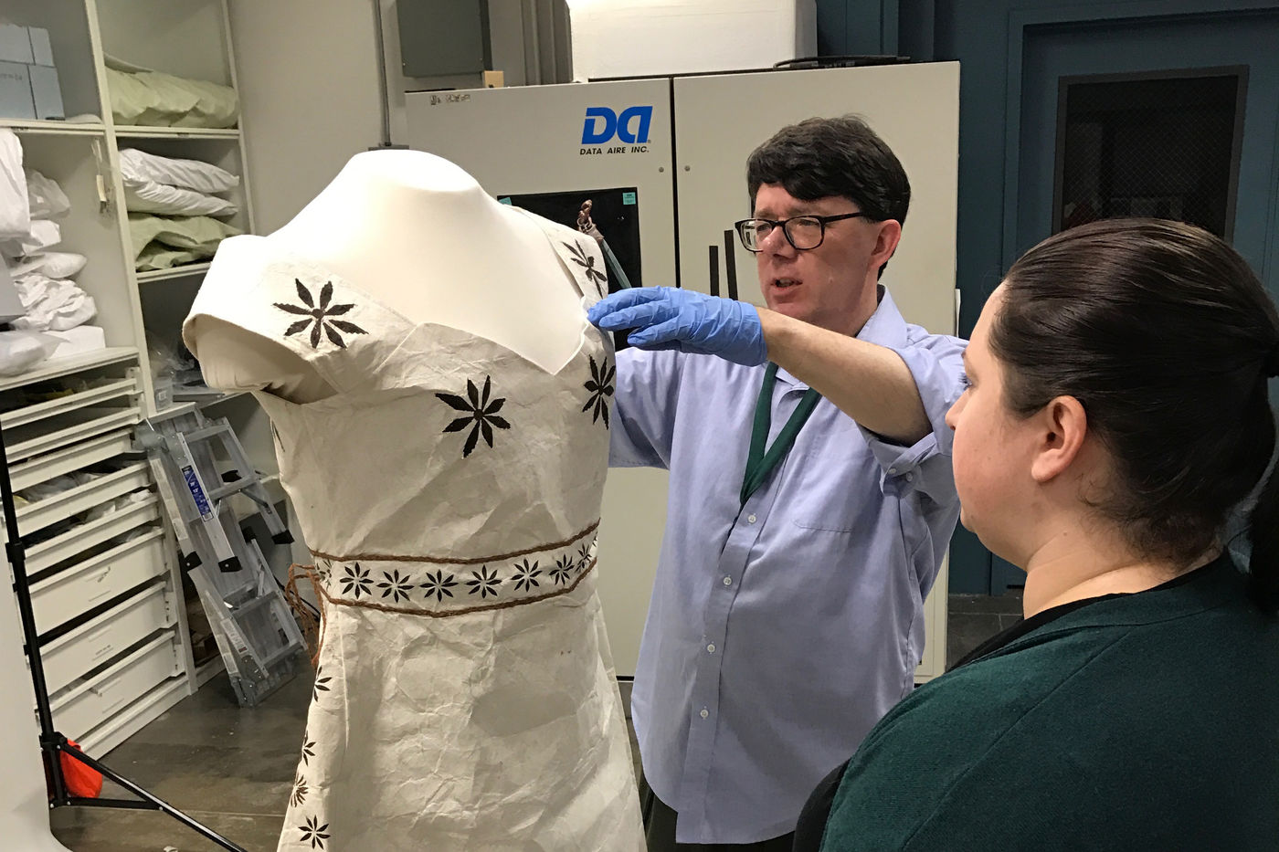 Field Museum staff members prepare a tapa wedding dress acquired from a Fijian dressmaker for installation.