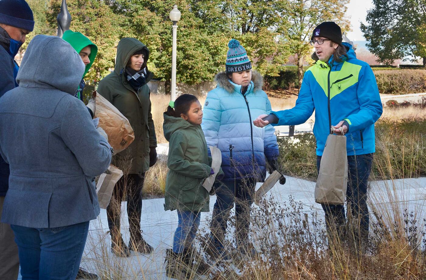 Research scientist Eli Suzukovich speaks at a 2019 seed harvesting event with the Chicago American Indian community.