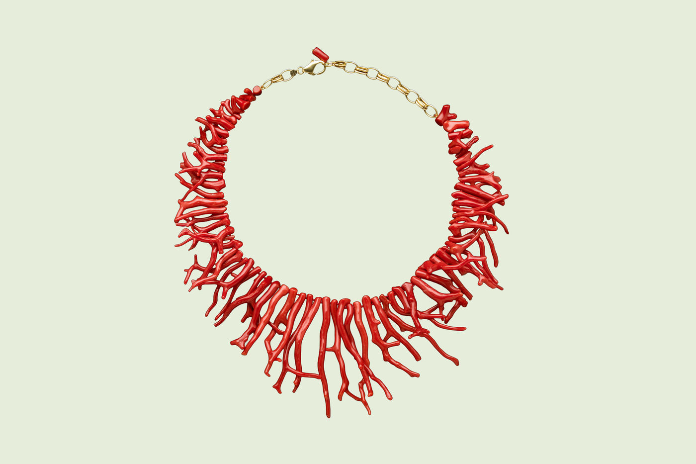  A circular necklace made up of long strands of red coral, connected by a golden clasp.