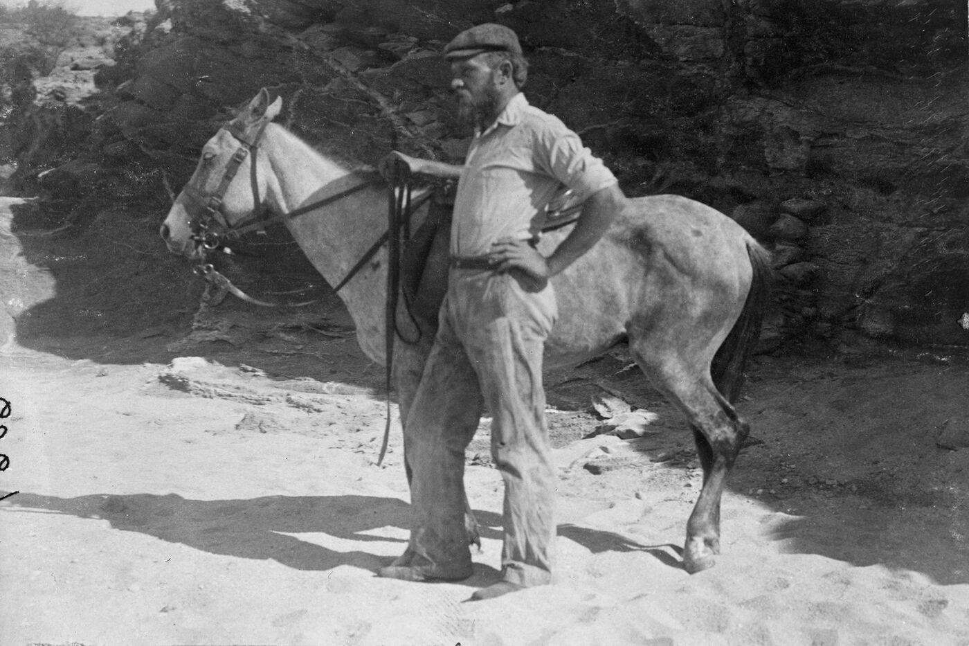 Carl Akeley standing with a horse in Africa, 1896