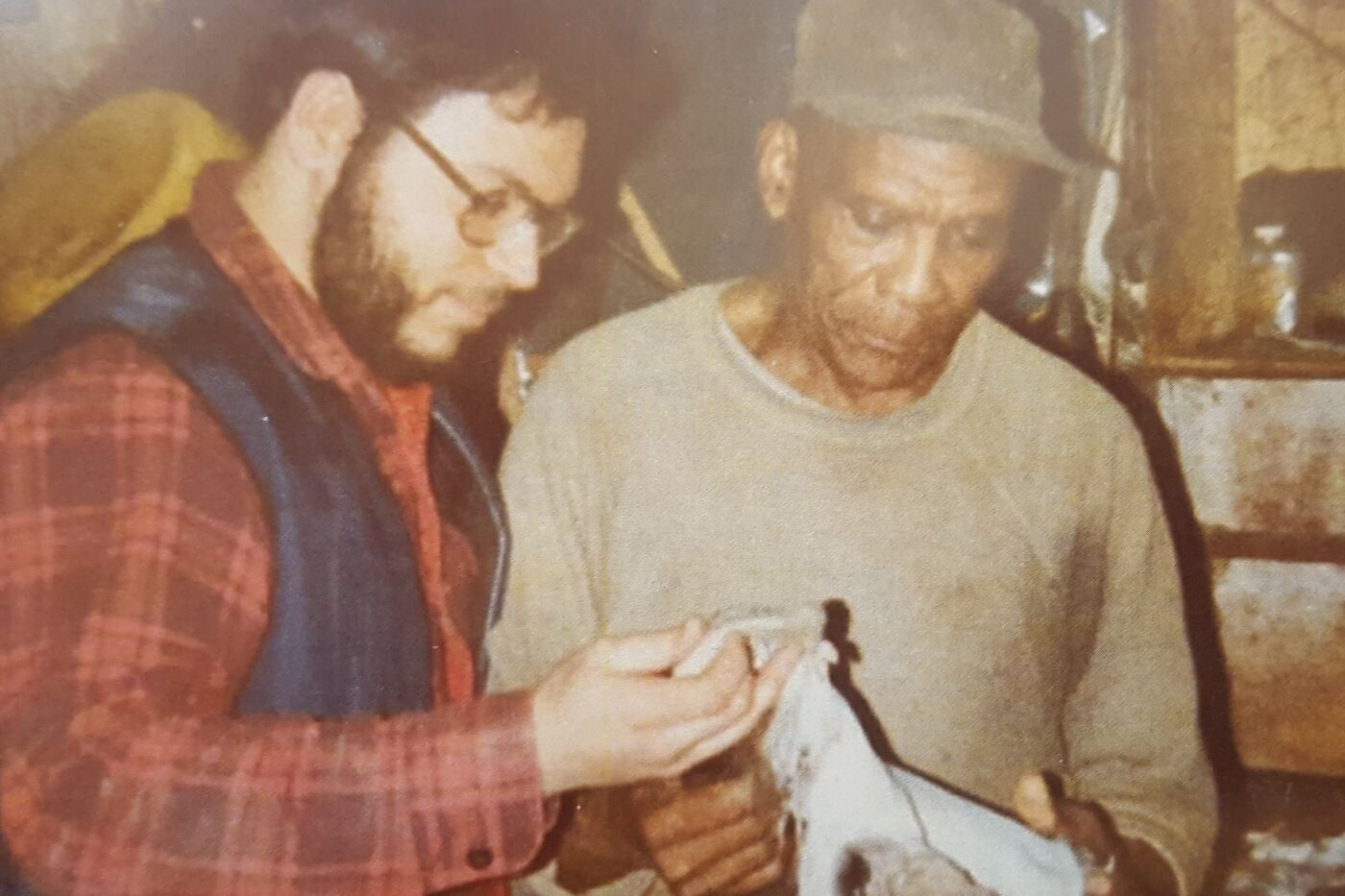 Two men holding and looking at what appears to be a hide they are preparing.