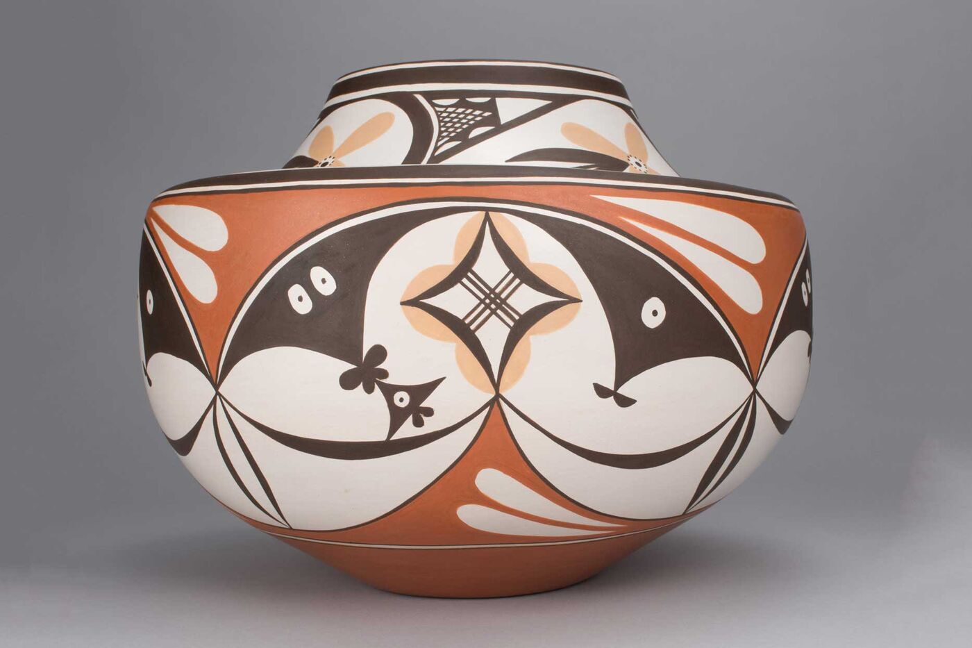 A pot with orange, brown, and yellow designs.