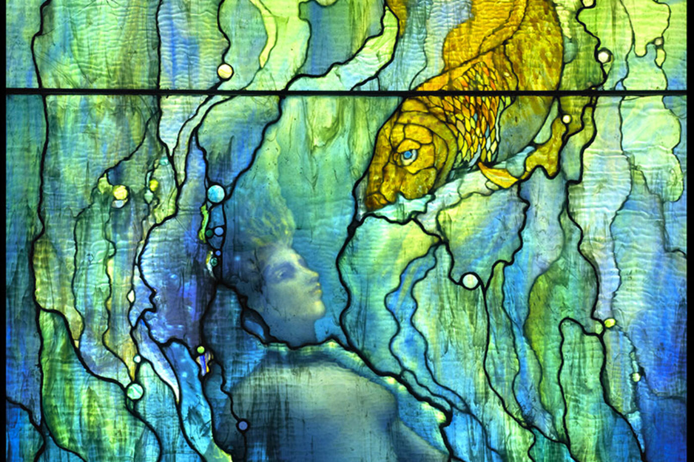 Detail of a Tiffany window, mermaid and fish, backlit, displayed in the Gem Hall.