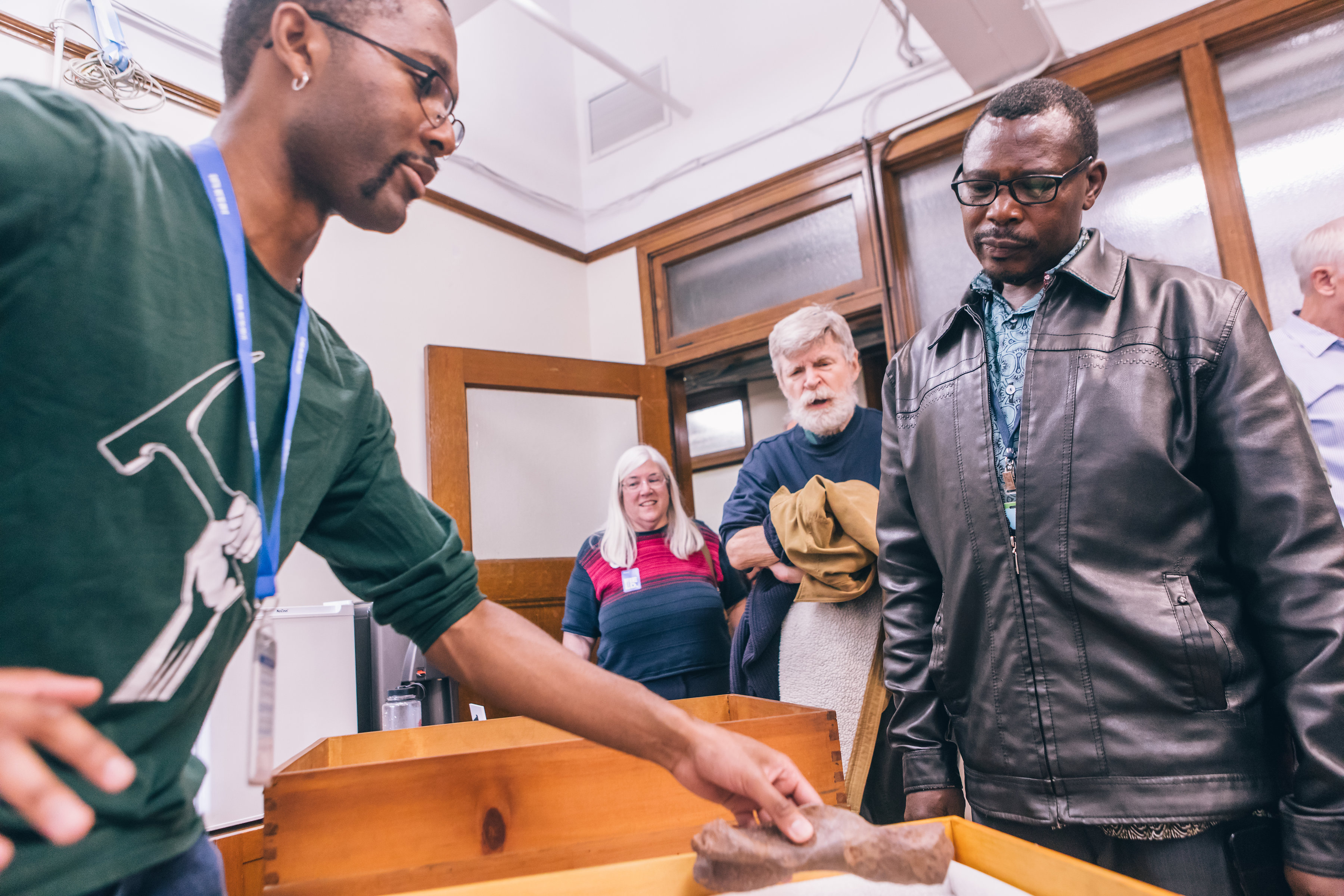 A museum staff member interacts with visitors in an office during an event.