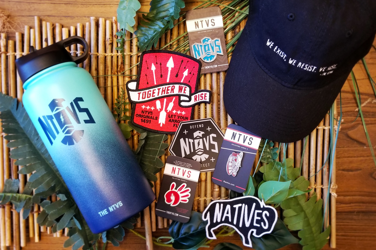 A selection of items available for purchase in the museum store, including a water bottle, cap, enamel pins and stickers.
