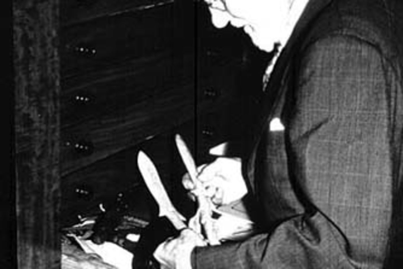 Alfred W. F. Fuller in England with his collection, holding in his hands two whale bone harpoon heads from the Marquesas Islands. Photo Archives ID # A96661.