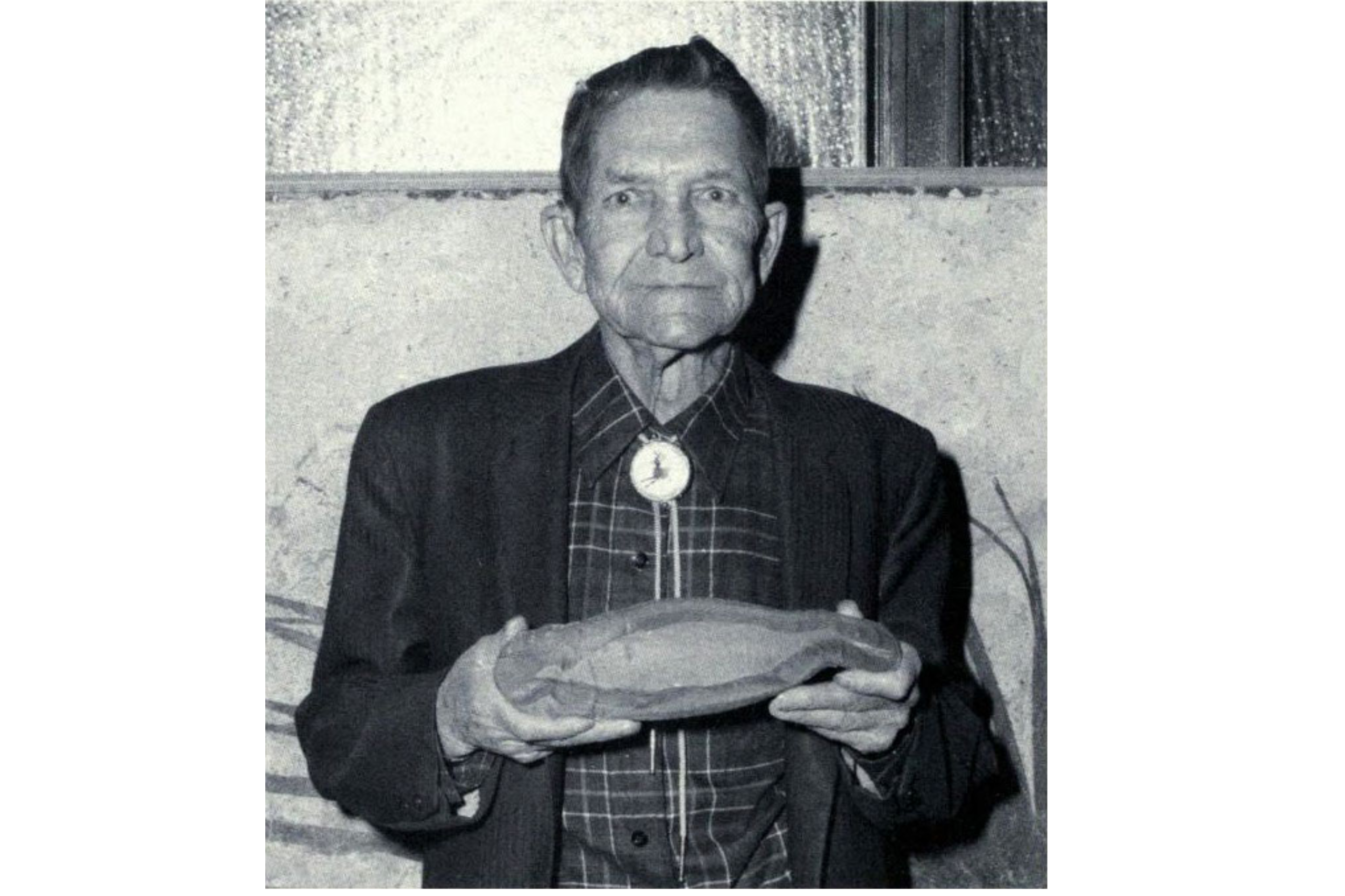 A man holding a fossil of a Tully monster
