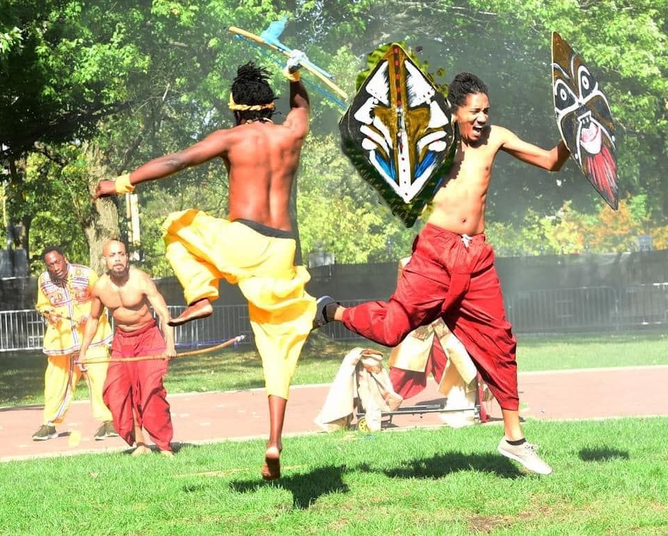 men carrying shields jump in a park