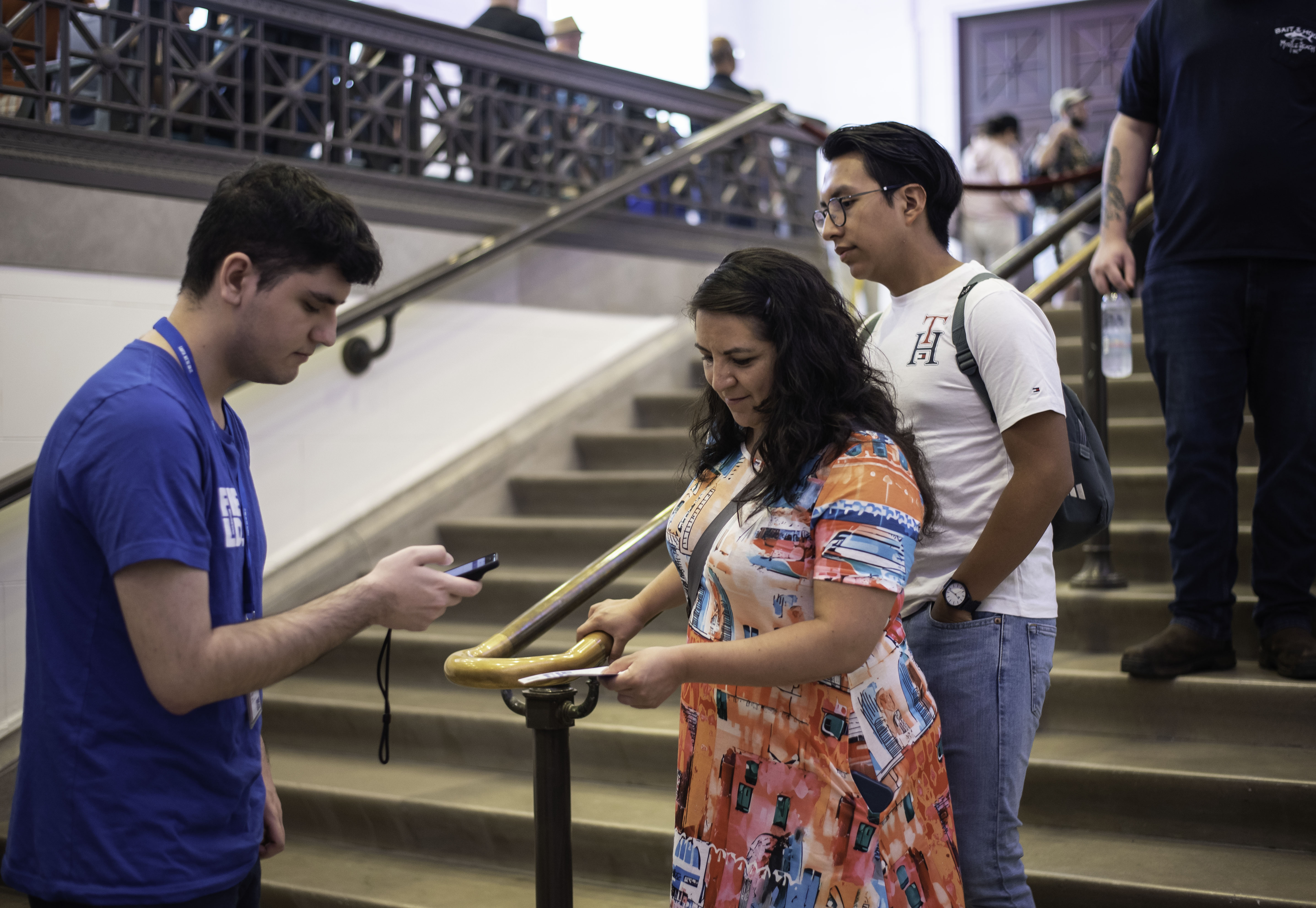 Museum visitors interact with a staff member while on stairs