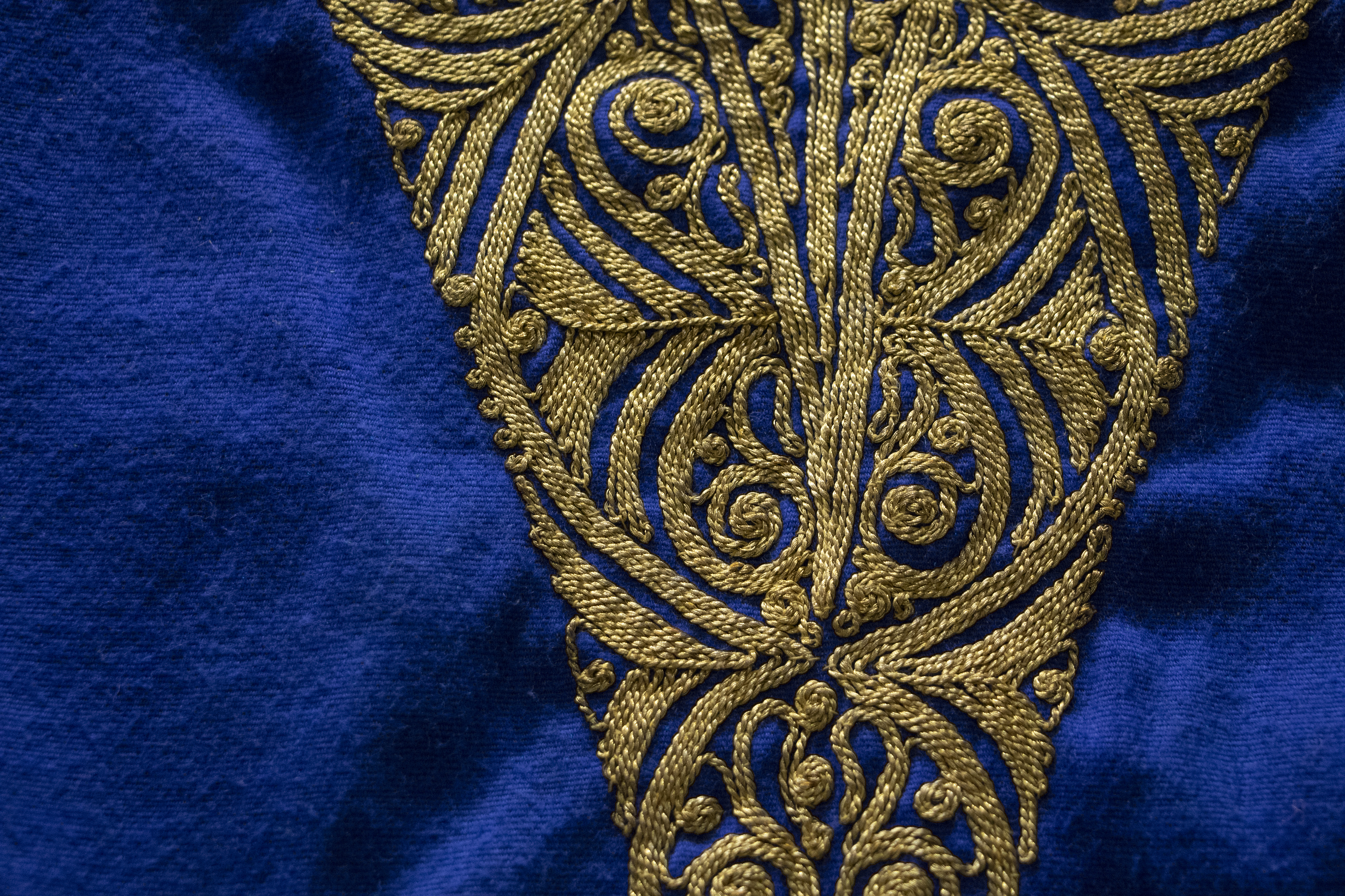 Bright blue fabric with intricate gold embroidered pattern