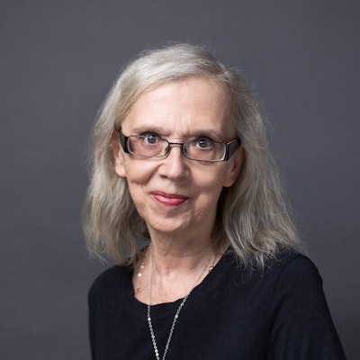 A woman wearing a black top and glasses.