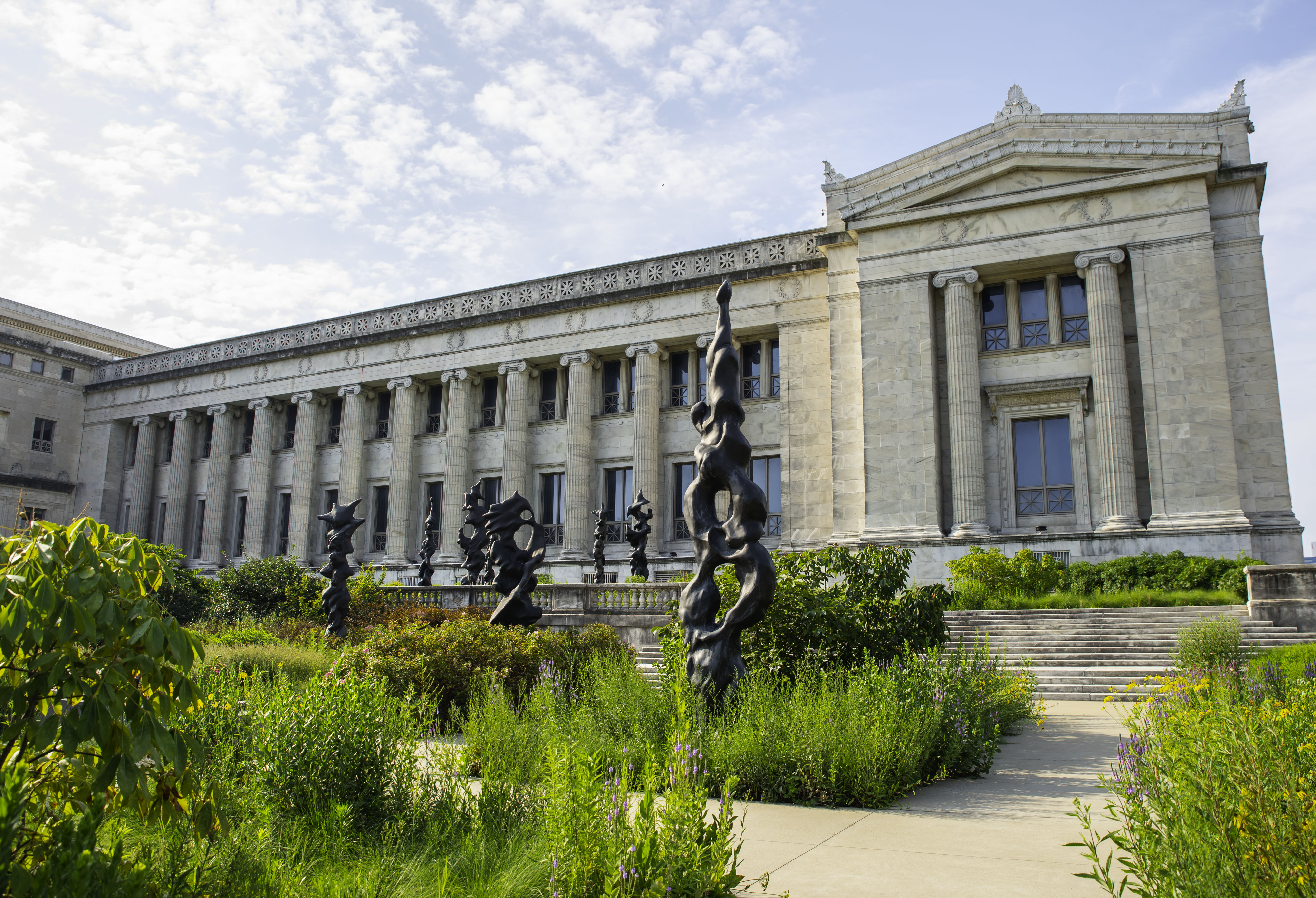 Native plant gardens with black sculptural totems, outside the museum building.