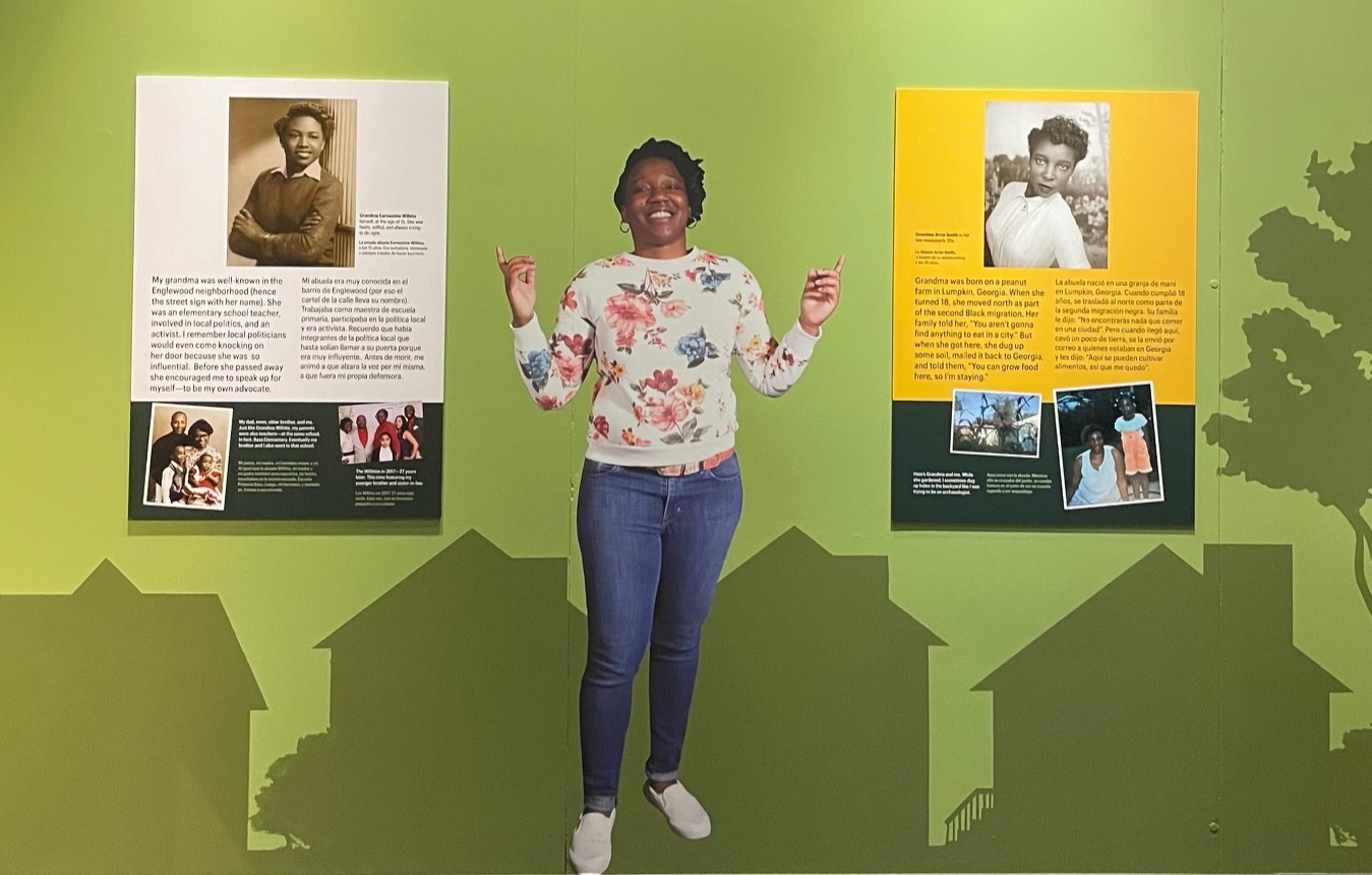 A woman standing in front of a graphic display in a museum exhibit