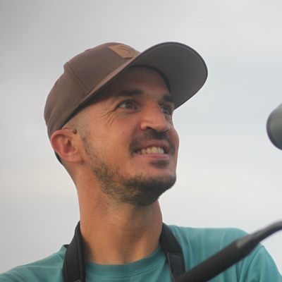 A man wearing a cap and green shirt
