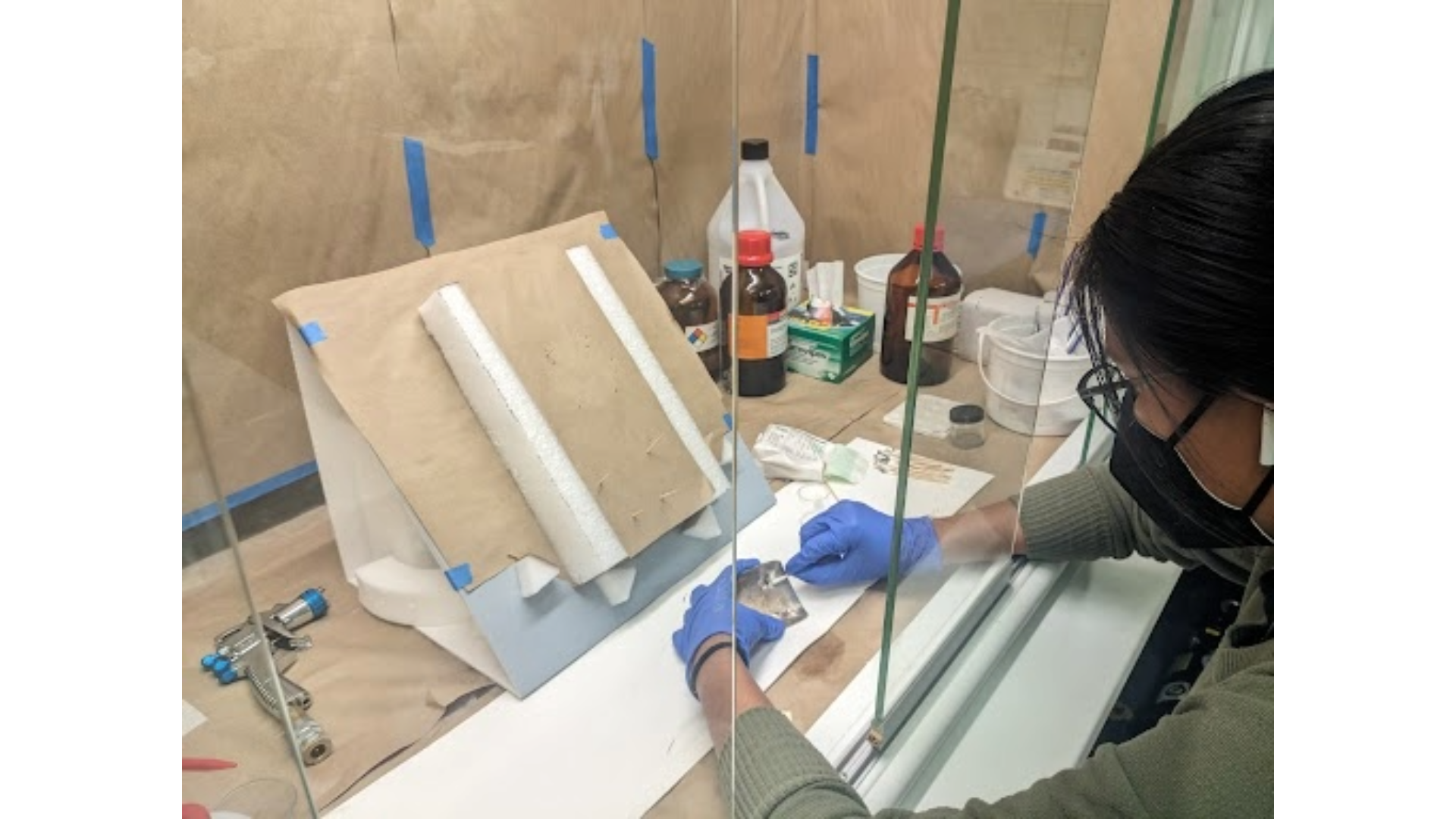 A museum staff member working on cleaning silver on a Navajo bow guard.
