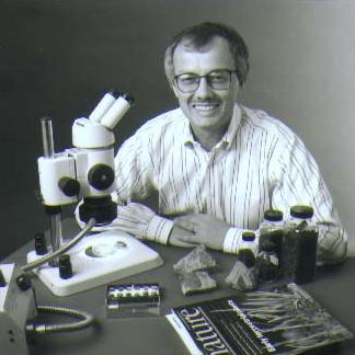 Peter Crane, Vice President Academic Affairs, Geology Department curator, with microscope, Nature magazine and fossil plant specimens environmental portrait