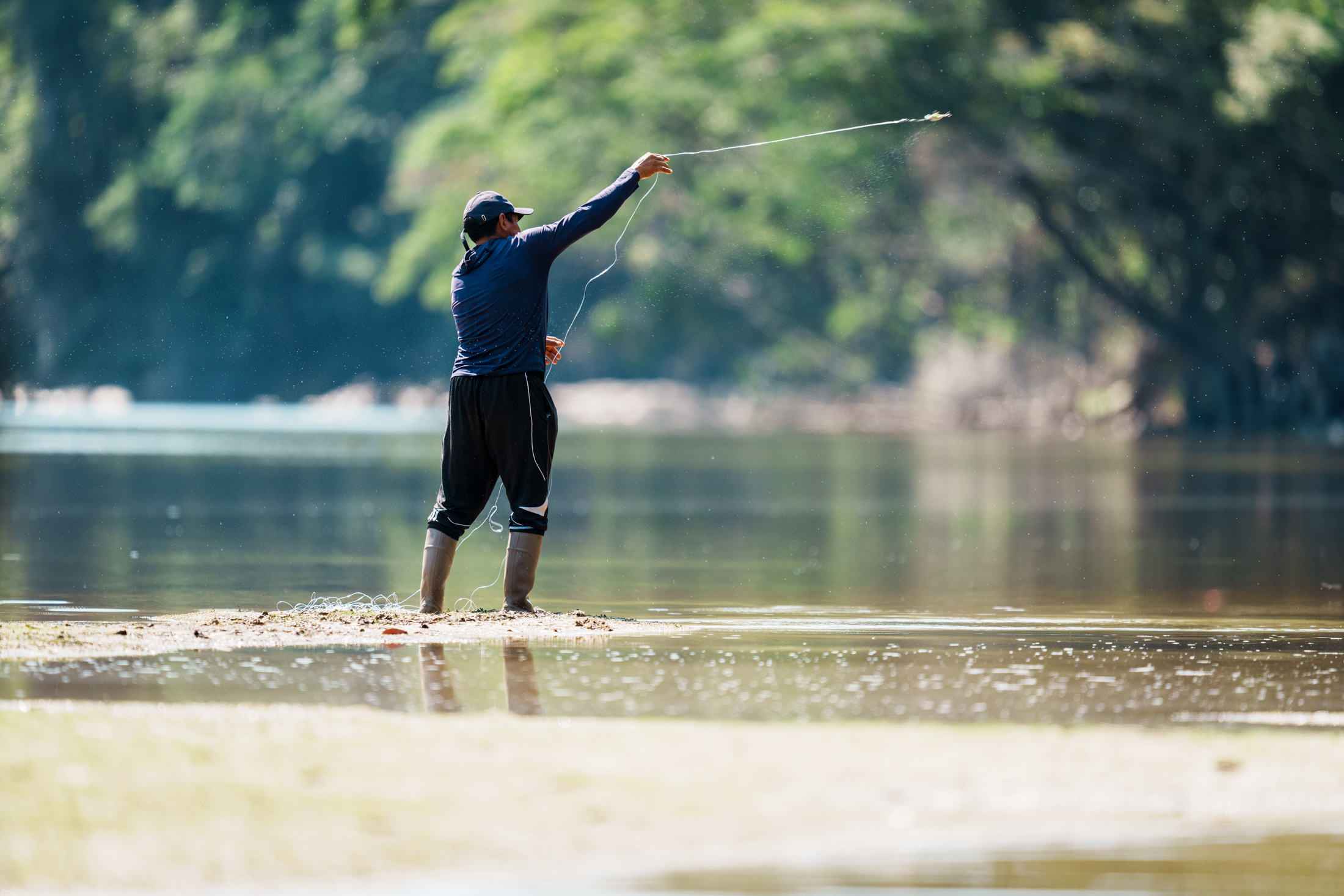 Local fisherman swings a line over the Essequibo River